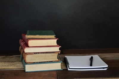 Books and a pen on white notebook